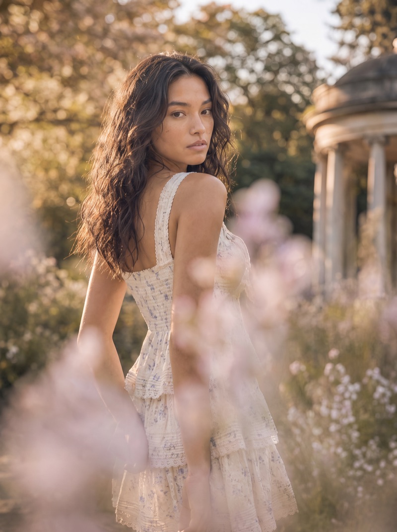 Previs frame: the model in a tiered white dress, standing at the rotunda steps, low sun behind