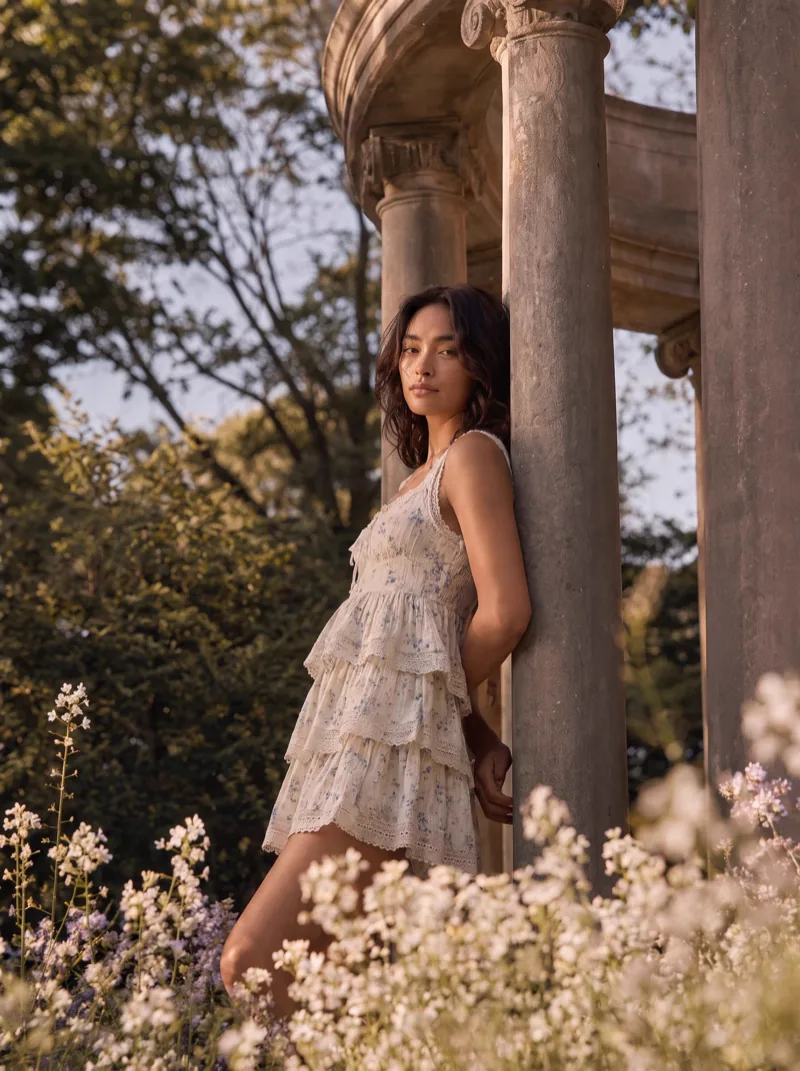 Previs frame: the model in a tiered white dress, leaning against a column of the rotunda