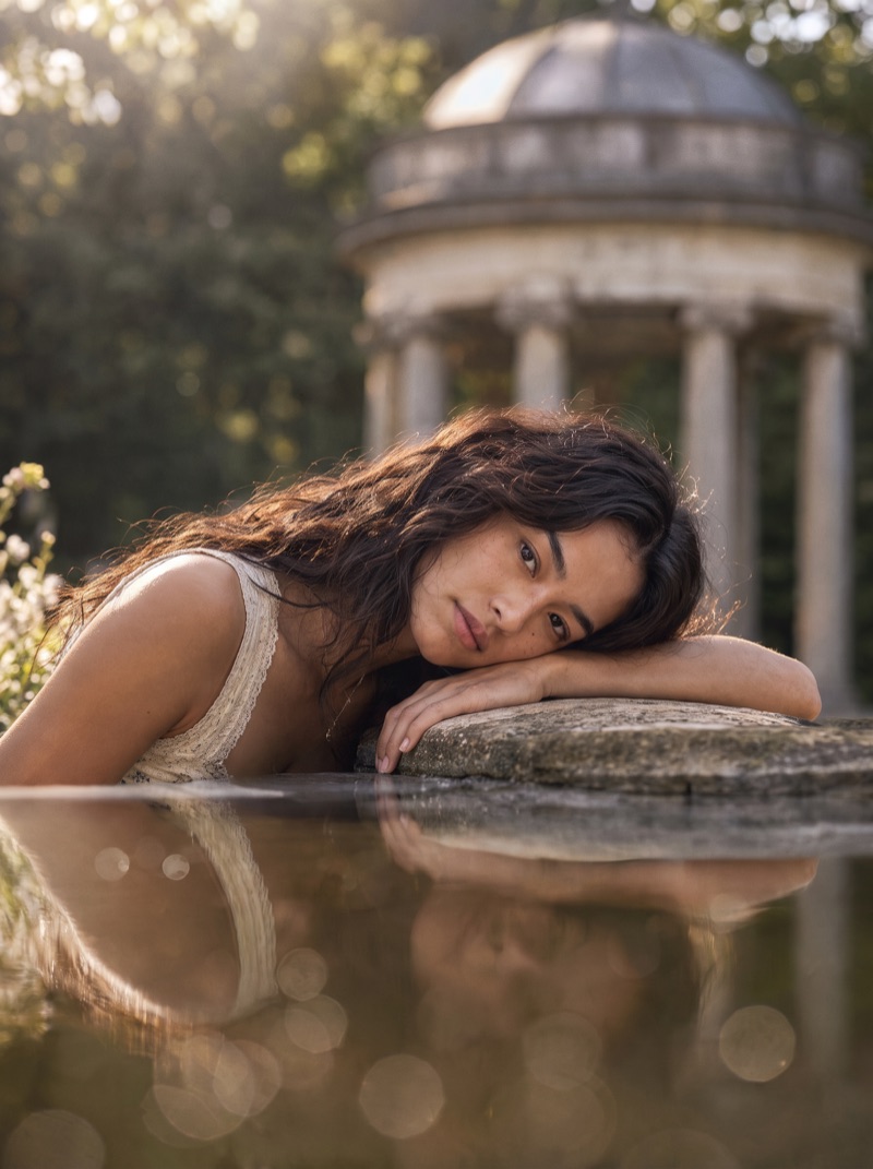 Previs frame: the model in a tiered white dress, wide shot with the rotunda behind her